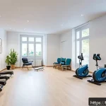 Home 18 신경근육 장애와 재활치료 병원 - A modern multidisciplinary rehabilitation clinic interior in France, featuring a spacious therapy ro...